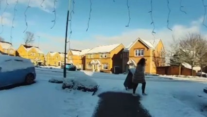 Girl slips while dragging rubbish bin on snowy driveway but quickly gets back up
