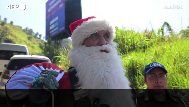 Guatemala, un pompiere vestito da Babbo Natale si cala da un ponte per regalare doni