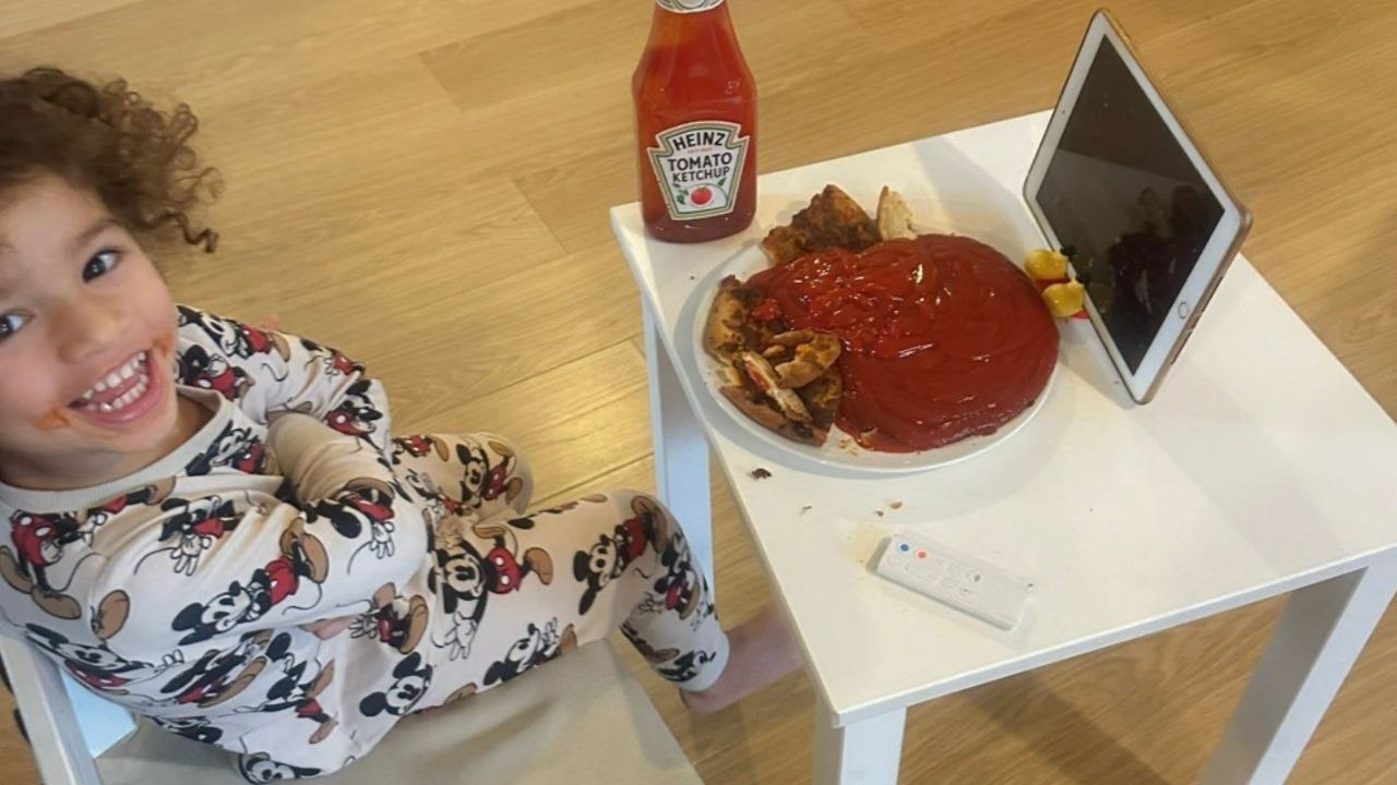 Kleinkind leert ganze flasche ketchup über pizza