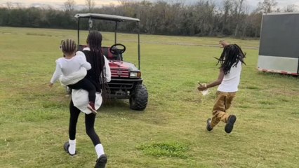 Boy runs excitedly and tumbles near the golf cart on the farm