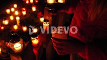 Graveyard, candles are lit on the grave at night