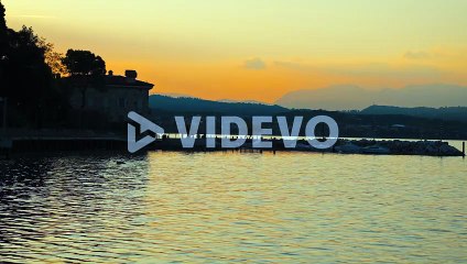 Golden hour sunset on a lake, calm water slowly moving with orange sky
