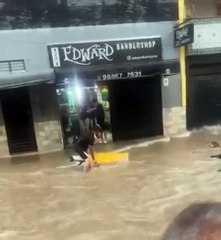 Homem surge com prancha de surf em alagamento no centro de Juiz de Fora