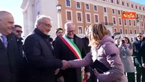 Il bacio di saluto tra Meloni e Salvini dopo il processo OpenArms all'inaugurazione di Piazza Pia