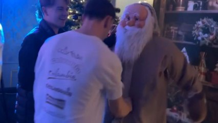 Life-size Santa Claus gets hit by a boy at a Christmas party
