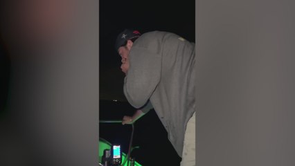Un tiburón salta encima de un barco mientras un grupo de hombres pescaba de noche