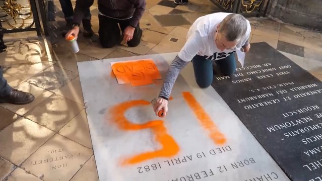 Activistas climáticos pintan la tumba de Charles Darwin en Londres.