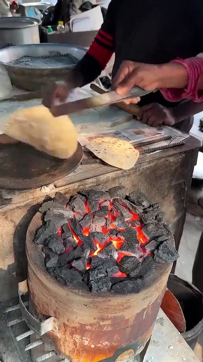 Grilling roti on hot charcoal