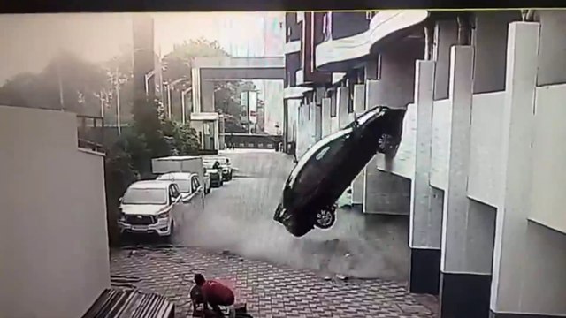 Car plunges from first-floor parking after driver accidentally reverses through wall