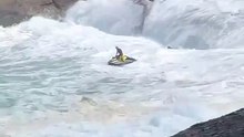 A jet ski rider rescues a surfer