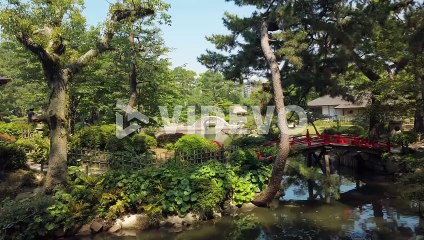 Japanese Garden Shukkei-en in Hiroshima, with a pond and a red bridge in may