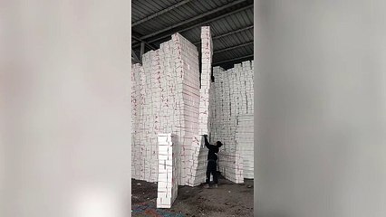 Worker handles tower of 28 foam boxes FOUR times taller than him