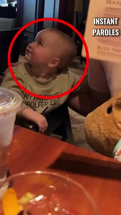 Ce bébé dit bonjour au serveur du restaurant puis se retourne aussitôt vers son papa