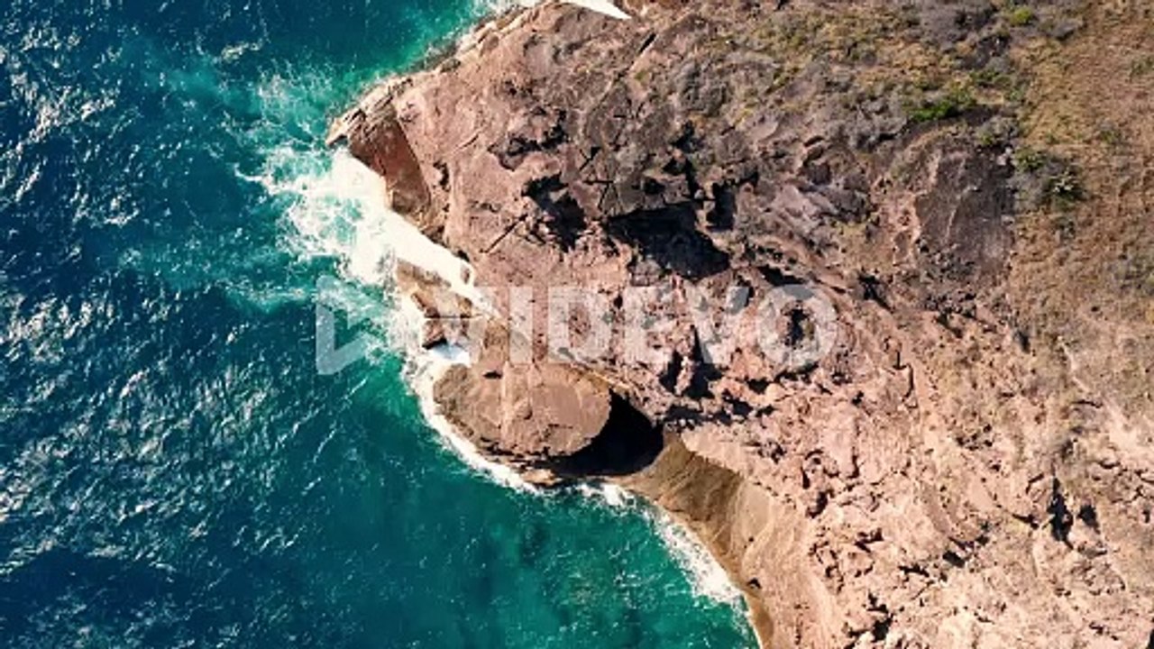 Aerial shot of ocean coast with views of waves and cliffs