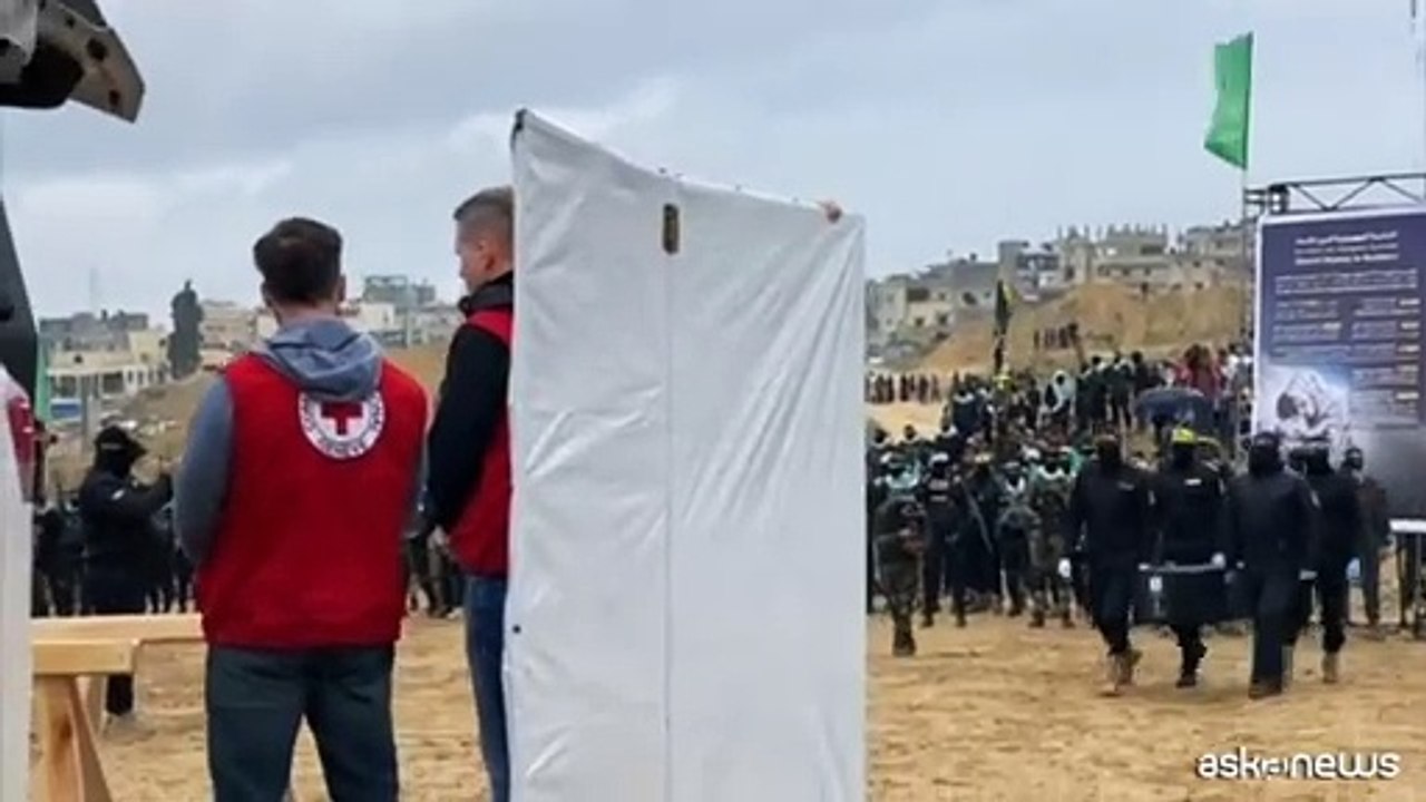 La cerimonia di Hamas per riconsegnare i corpi, bare nere con le foto