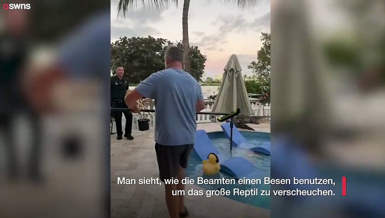 Polizisten helfen Anwohnern, einen riesigen Alligator mit einem Besen aus dem Garten zu vertreiben