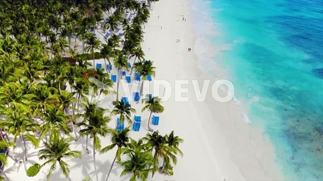 Breathtaking aerial view showcases a stunning white sandy beach and crystal-clear turquoise ocean