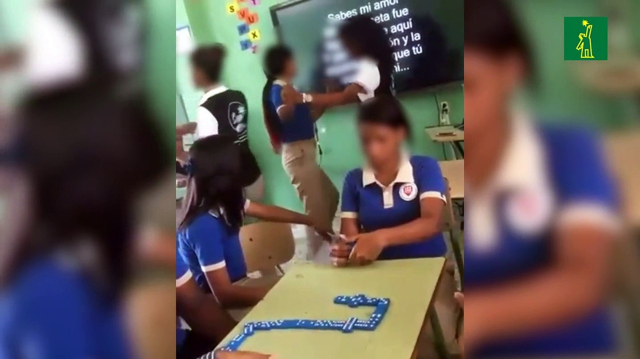 Estudiantes bailando y jugando dominó en el aula
