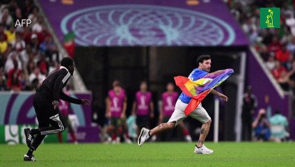 Un hombre con una bandera arcoíris entra en la cancha del Portugal-Uruguay
