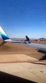 Man climbs onto the wing of a plane waiting for take-off after breaking into a Las Vegas airport runway area
