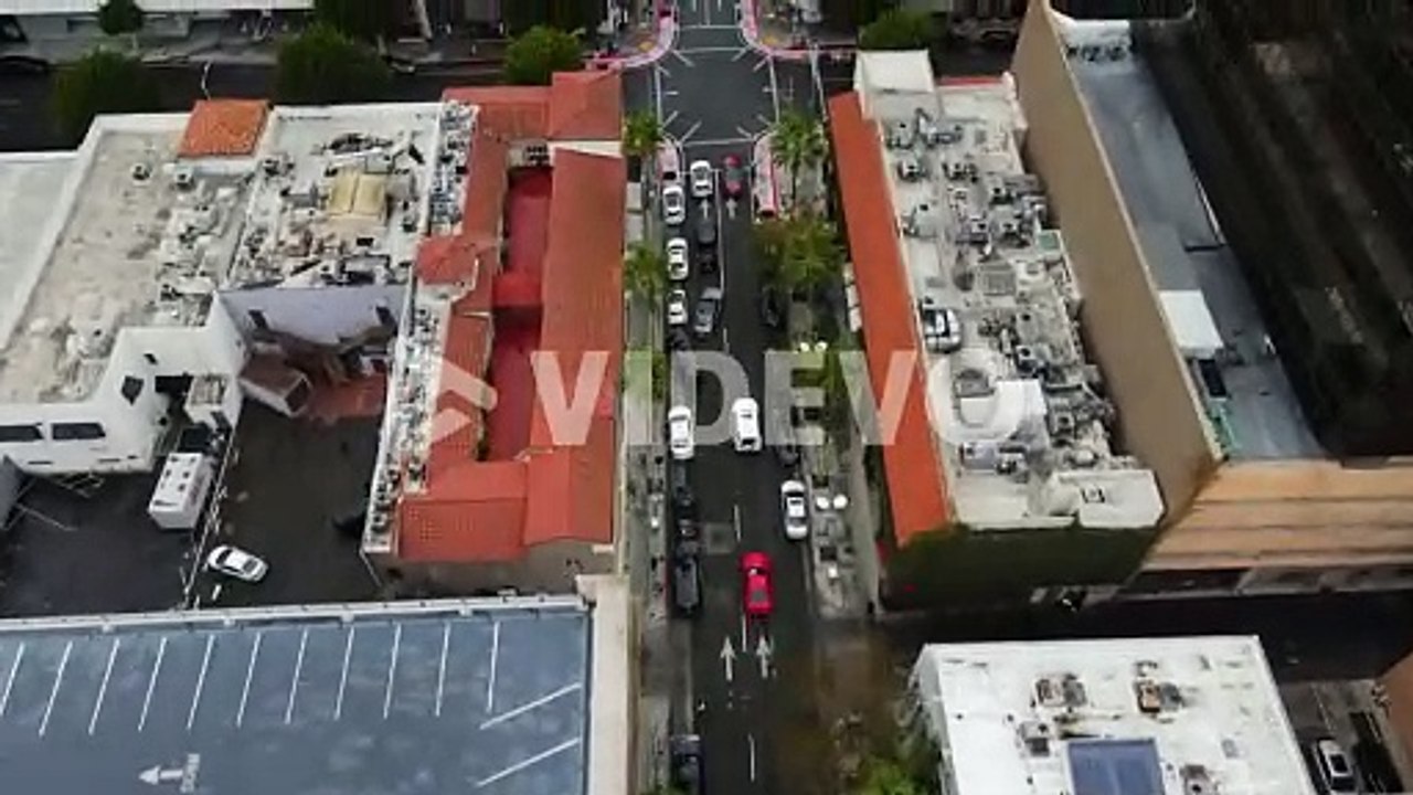 Aerial view tilting over streets of Beverly hills, revealing the skyline, in Los Angeles, USA