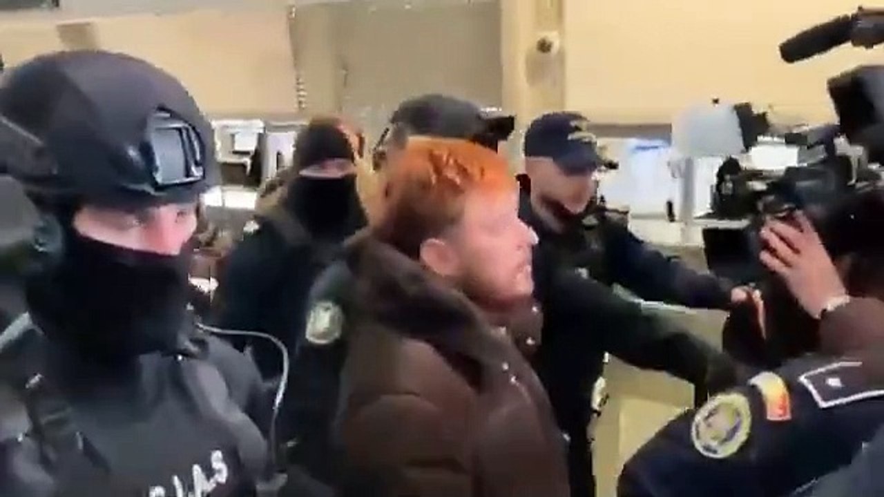 Mohamed Amra à l'aéroport de Bucarest en train d'être rapatrié en France avec à nouveau le sourire