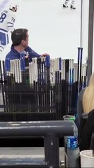The _stick man_ at NHL games keeping his hand on the stick of their player with the puck.
