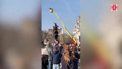 Un hombre escala el Big Ben para colgar en él una bandera de Palestina