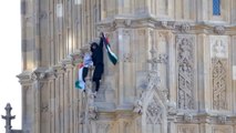 Un hombre trepa la torre del Big Ben con una bandera de Palestina