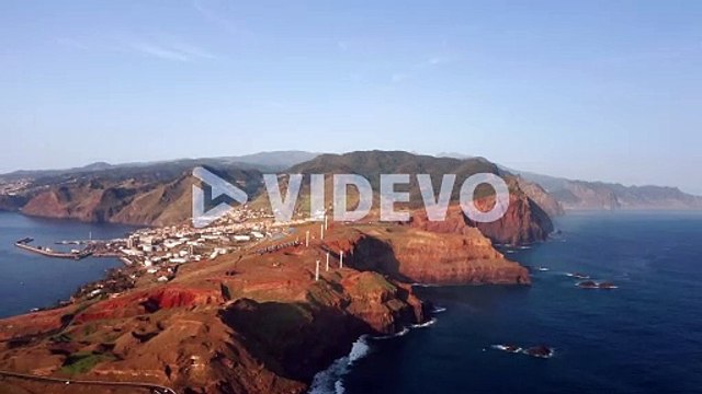 Madeira island with view of Caniçal town on rugged coastline, aerial