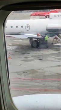 Cet employé d'aéroport utilise un cône pour déneiger une aile d'avion...