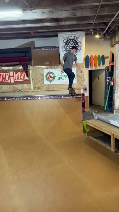 Un homme tente de faire du skate sur une rampe et chute