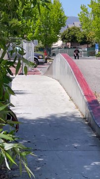 BMX rider grinds ledge and jump over then falls forward and lands on his leg