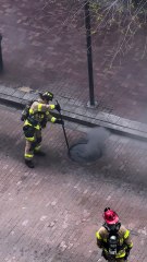 Fire Crews work near smoking manhole cover Downtown Pittsburgh