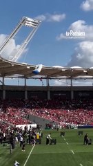 Un parachutiste s'accroche au toit du Stadium