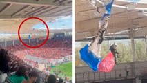 Susto en un partido de rugby: ¡Un paracaidista se queda enganchado en el tejado la grada!