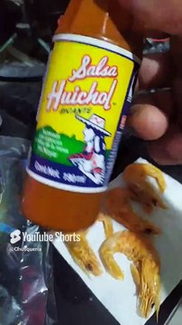 comiendo mariscos secos deshidratados camarones gambas con mucha salsa picante