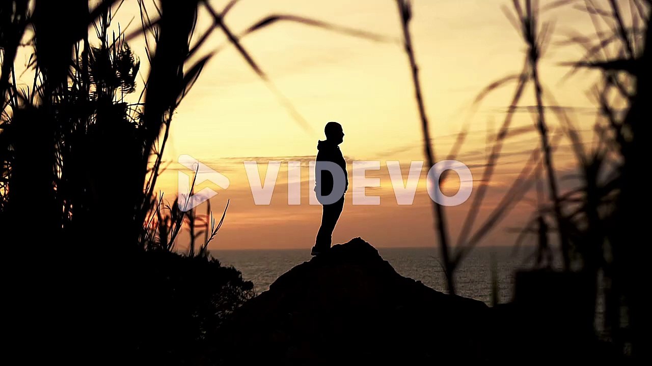 Silhouette of a man on a mound at sunset, golden hour