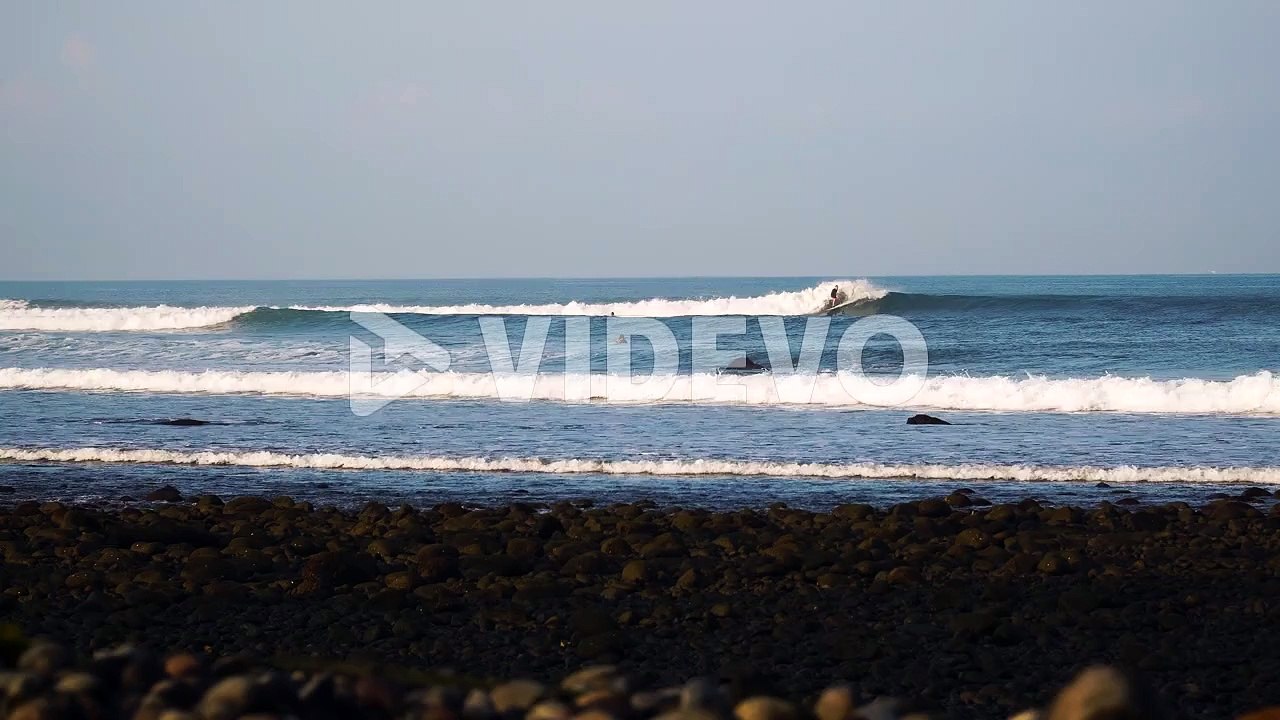 Surfer surfing on breaking wave in tropical island