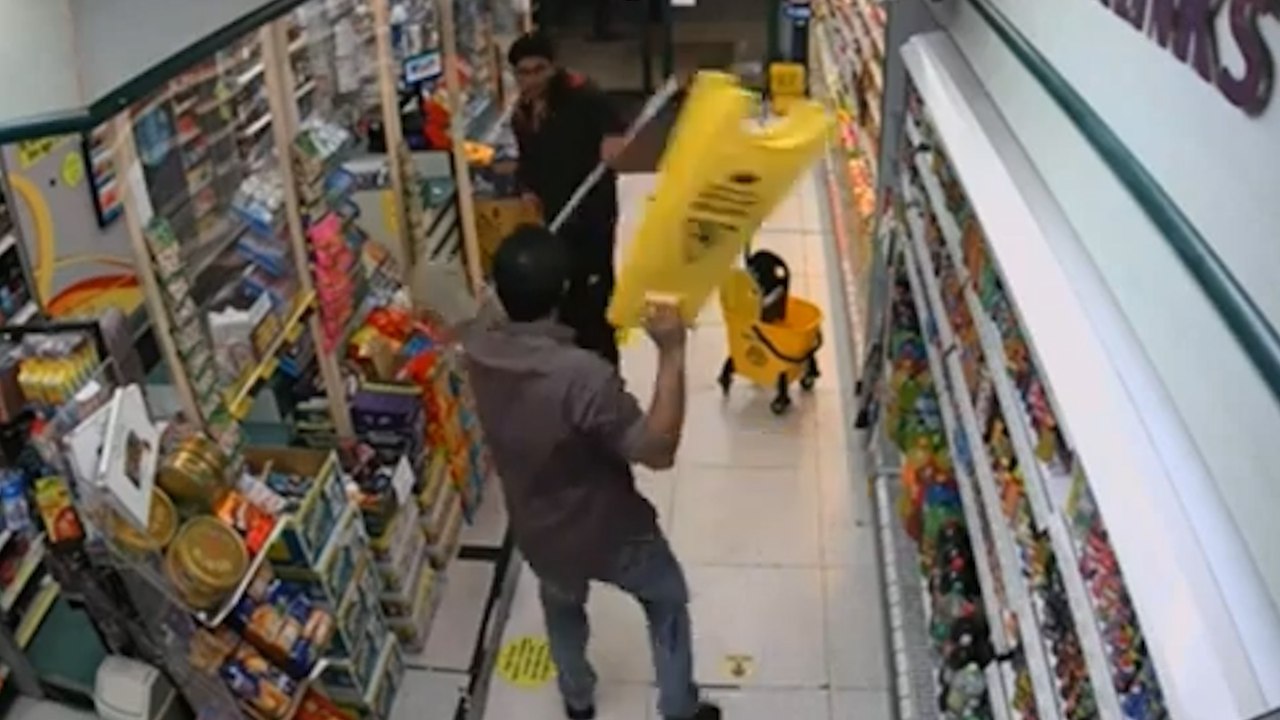 Moment, in dem ein Ladenangestellter einen Angreifer mit einem Messer abwehrt – mit einem Mopp
