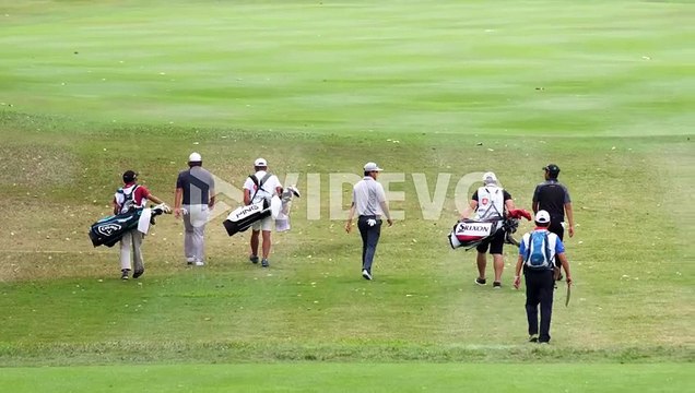 Golf players putting on the green during a summer golf tournament at a municipal golf course