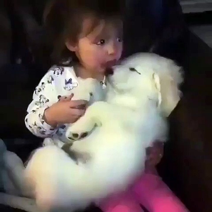 Admire how this little girl holds a puppy's paws and gently kisses her muzzle. Too cute !