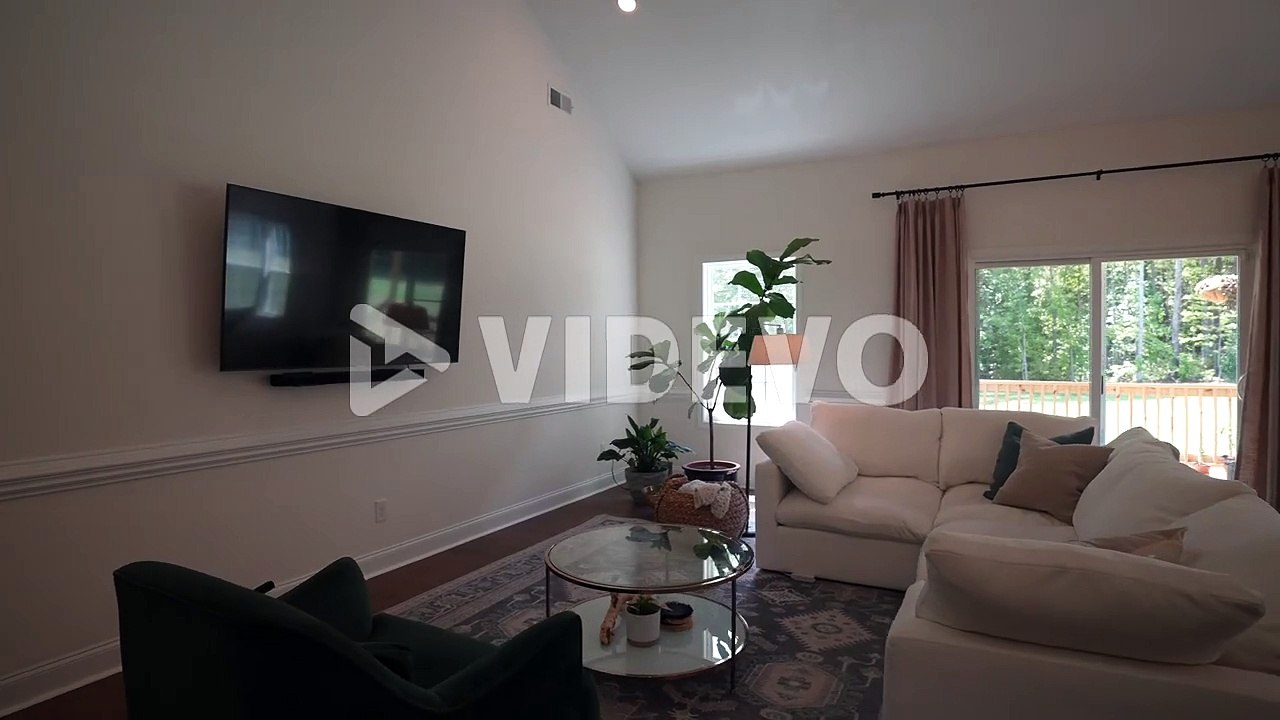 Beautifully designed living room with an open concept kitchen and vaulted ceilings