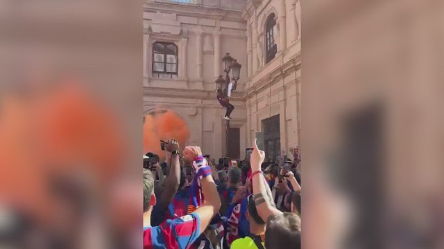 Lamentable escena: un fan del Barça subido a una farola intentando quemar una camiseta del Madrid