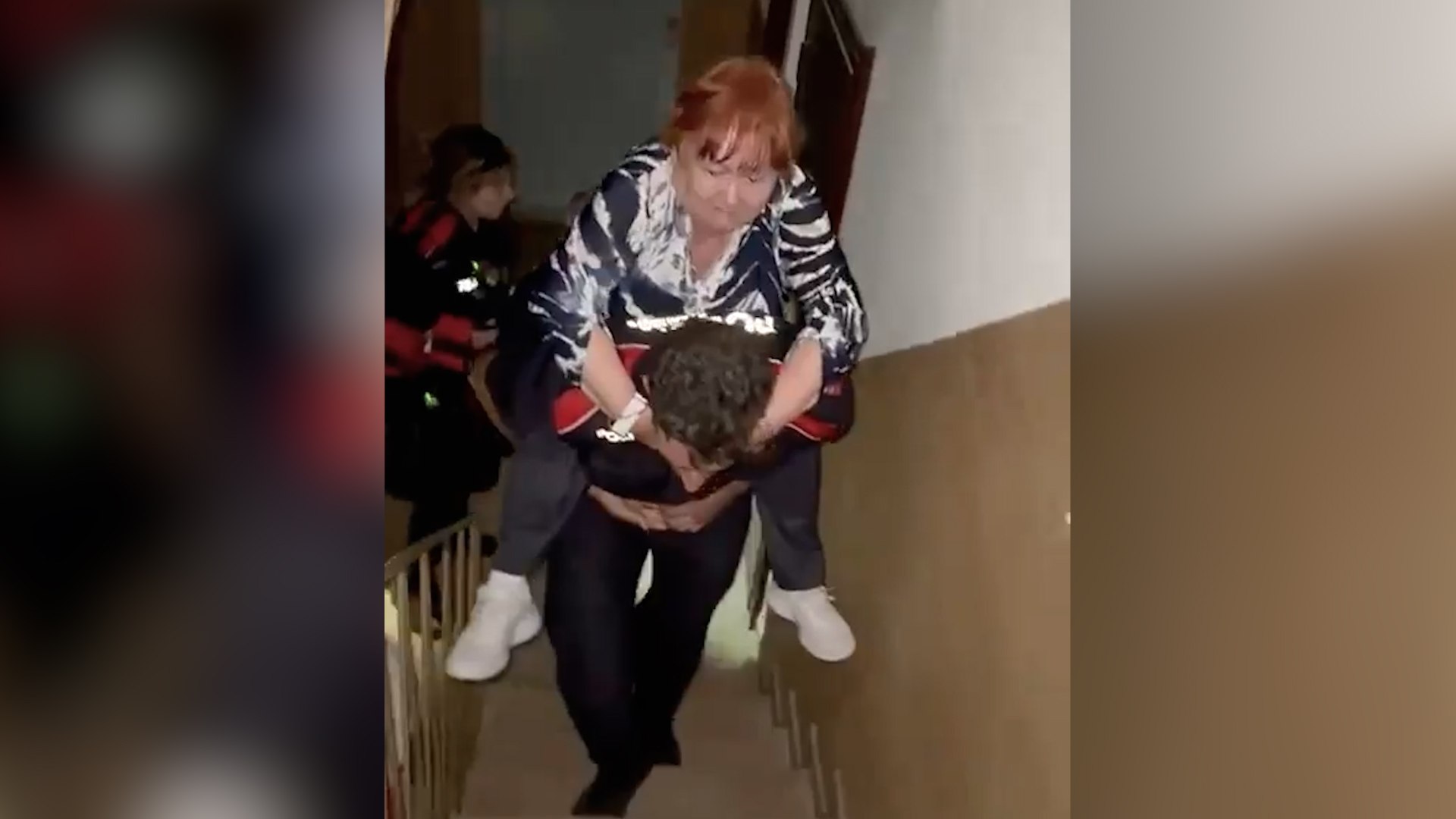 Un mosso sube 'a caballito' a una mujer con problemas de movilidad al piso 11 por el apagón