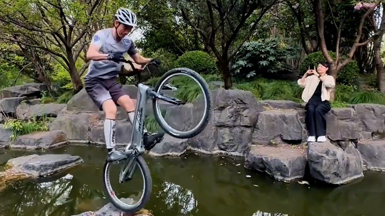 Tollkühner radfahrer überspringt flusssteine in atemberaubendem stunt