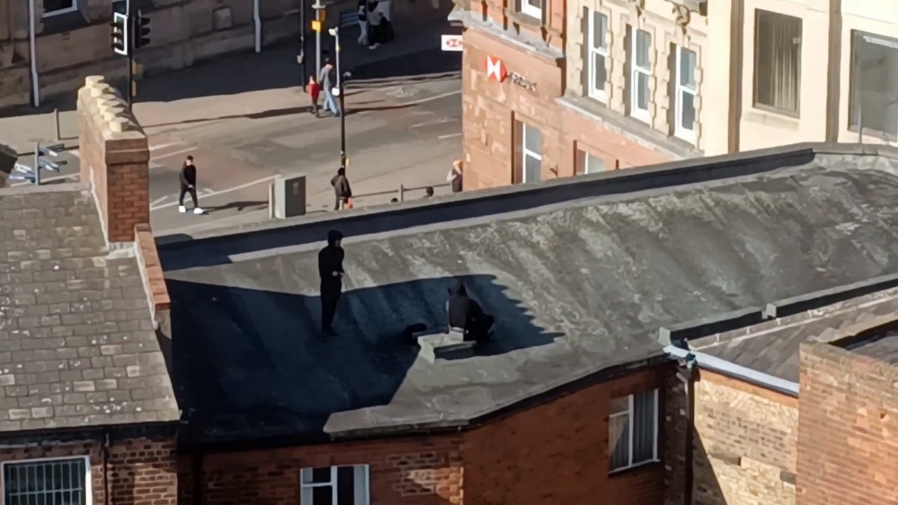 Pair of hooded males seen clambering over rooftops in Wolverhampton city centre