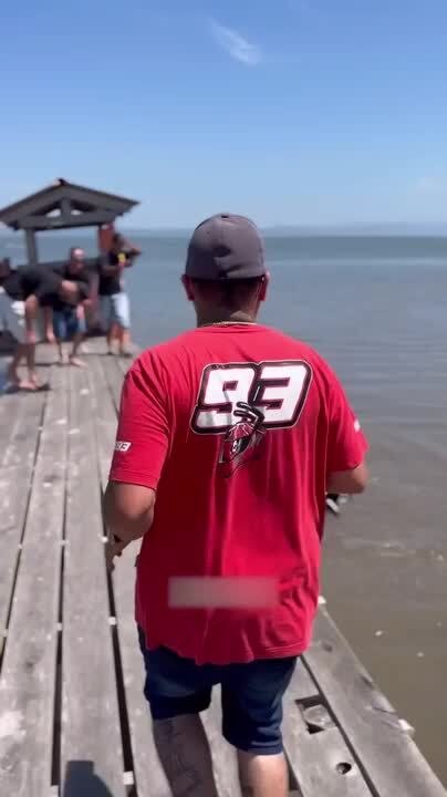 Man Attempts Wheelie on River Dock but Loses Balance, Sending Bike into Water