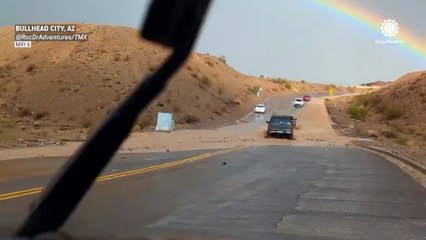 Stunning rainbow spotted over flooded Arizona road
