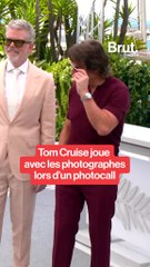 Tom Cruise joue avec les photographes à Cannes.